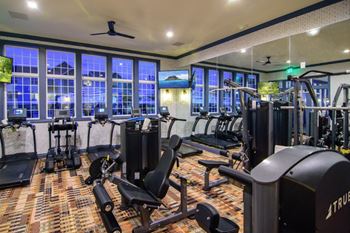a gym with cardio equipment and windows at night at Elan Park, Columbus, OH 43231